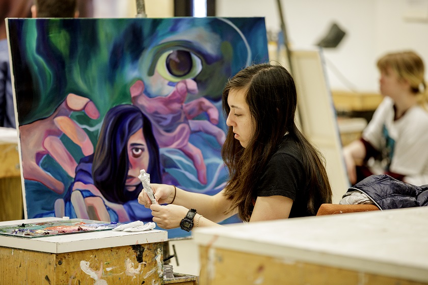 A student paints at a class