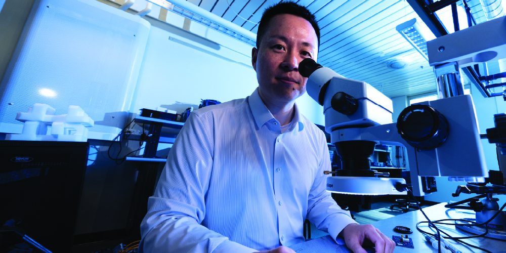 Researcher looks through microscope in lab setting