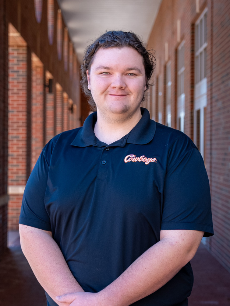 student posing behind ConocoPhillips OSU Alumni Center