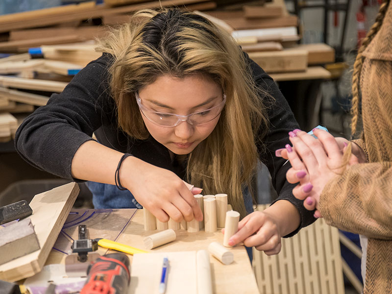 Architecture student building structure in lab