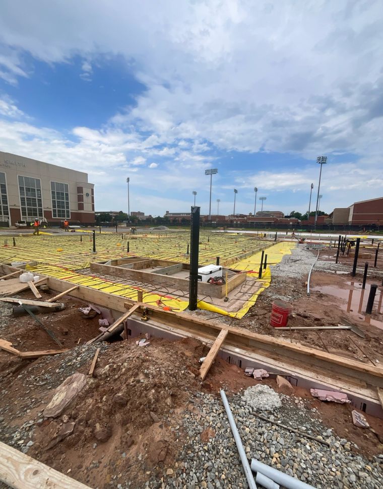 Rebar gets laid out in grid as workers prepare to pour slab