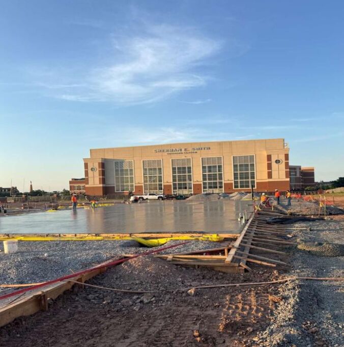 Wet concrete reflects building in background as it begins to dry