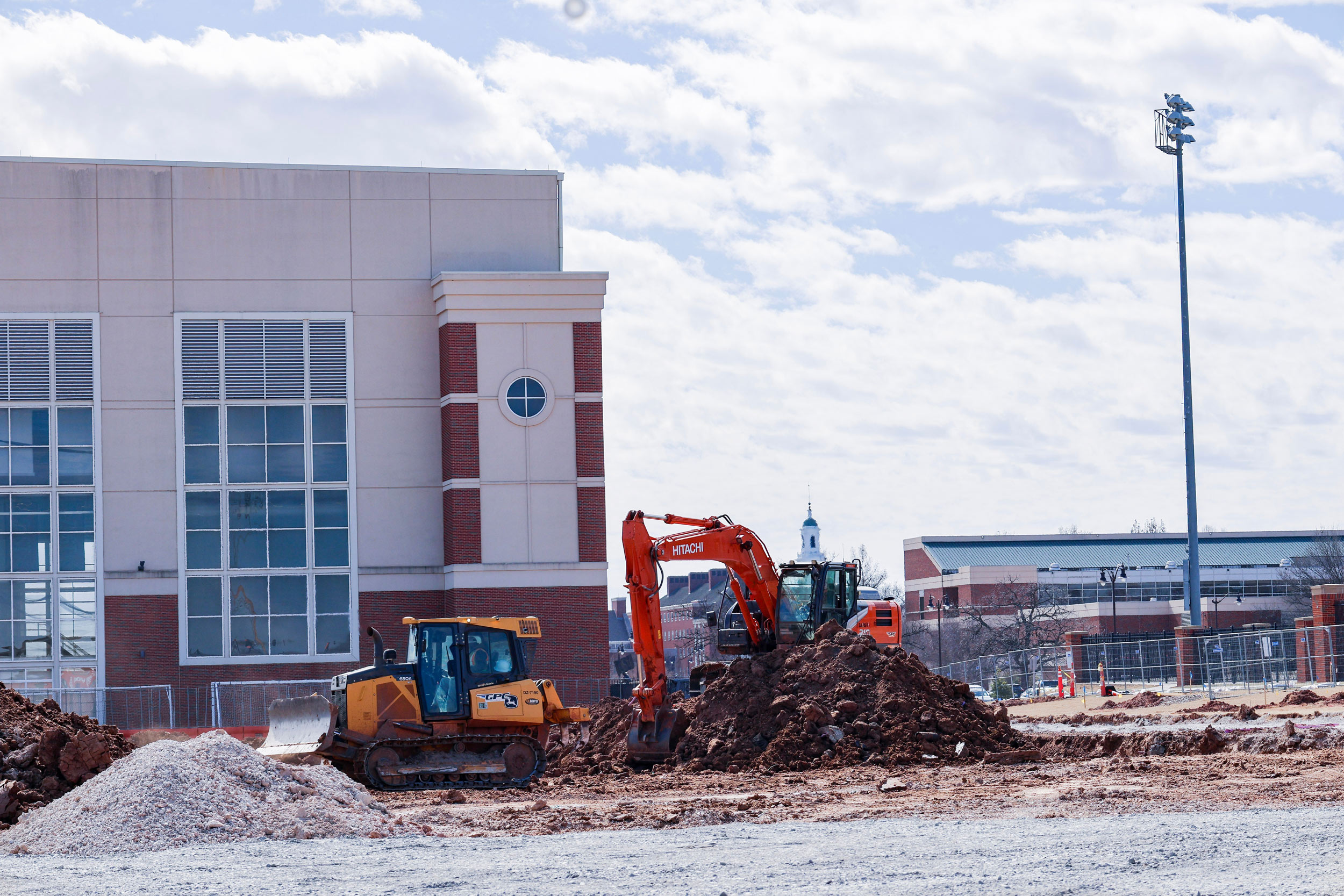 an excavator and bulldozer move dirt to prepare a for building construction