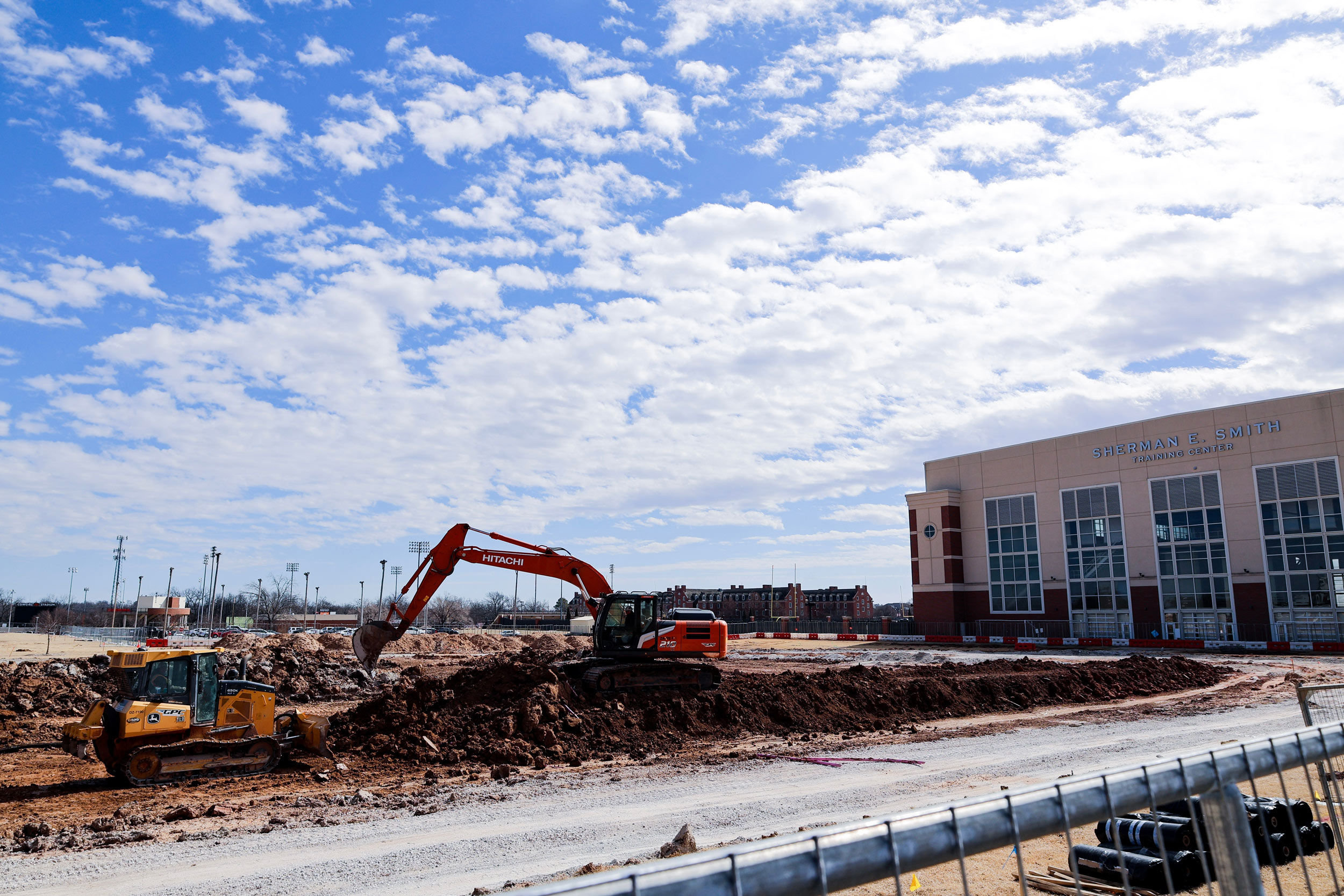 an excavator and bulldozer move dirt to prepare a for building construction