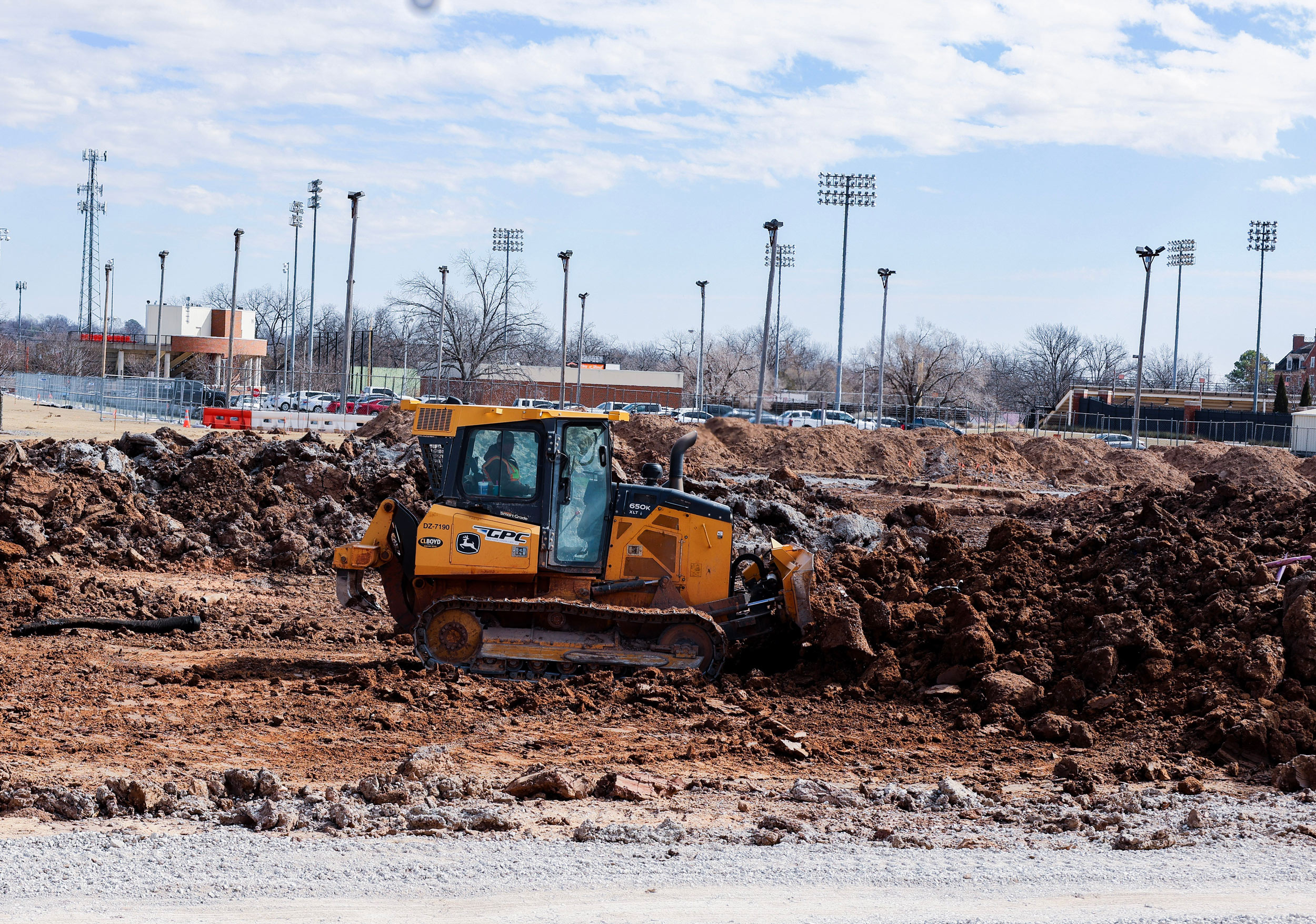 a bulldozer pushes dirt piles to even out the ground for building construction