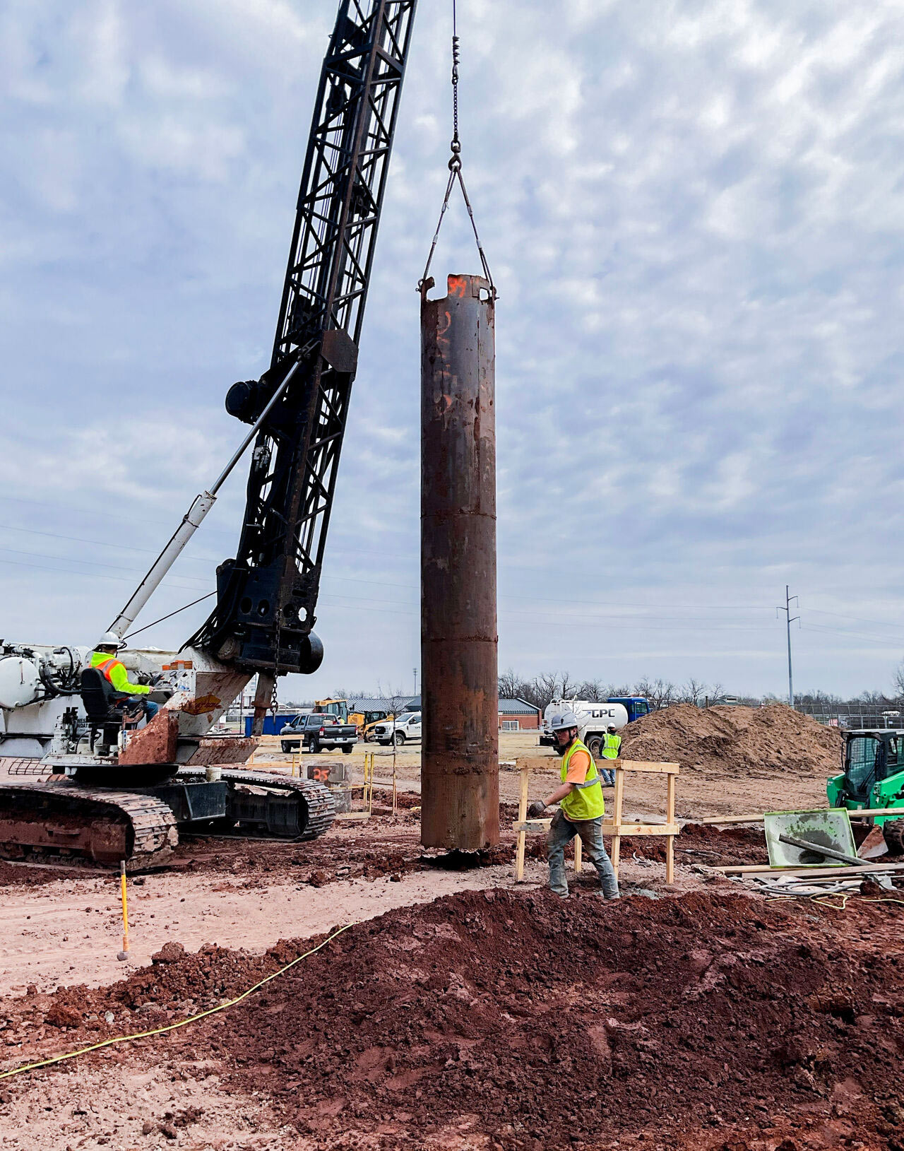 construction workers use heavy equipment to place the building's grade beam