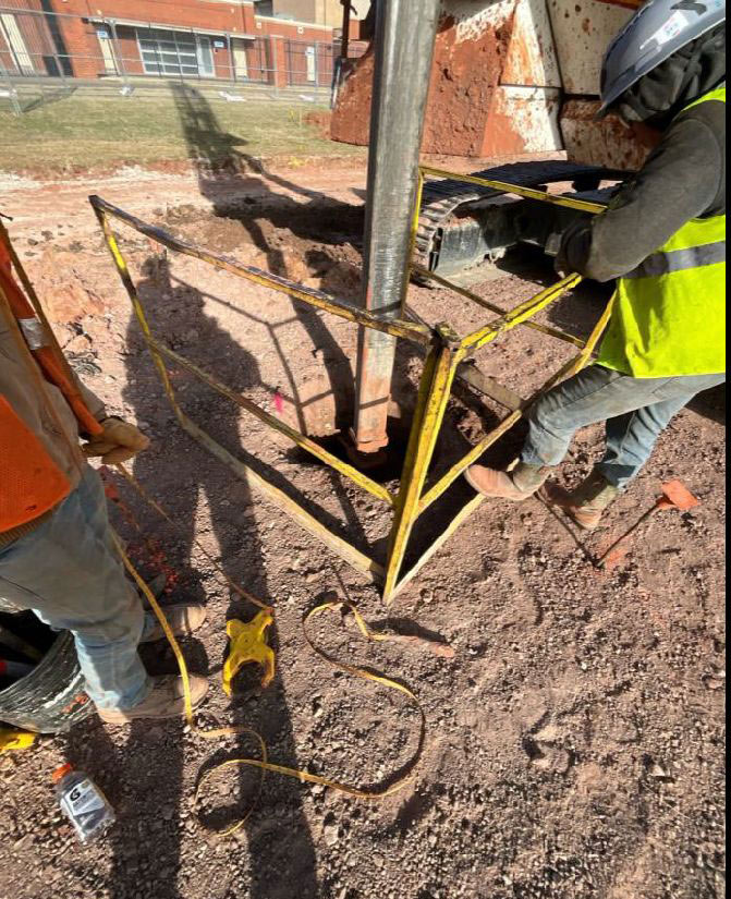 construction workers pour concrete piers for a building foundation