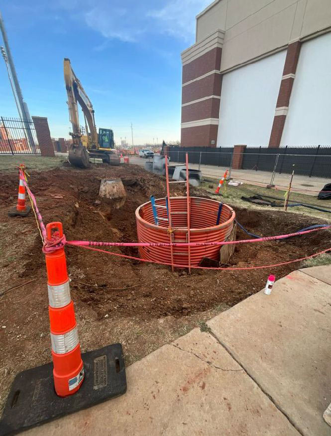 construction workers pour concrete piers for a building foundation
