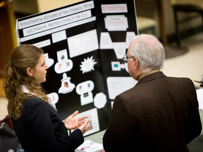 A student discusses their research findings with a faculty member.